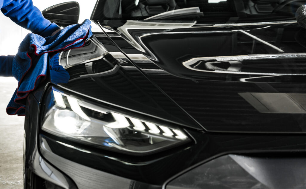 Autoreinigung Basel mit professioneller Lackreinigung und Hochglanz-Finish an einem schwarzen Fahrzeug.