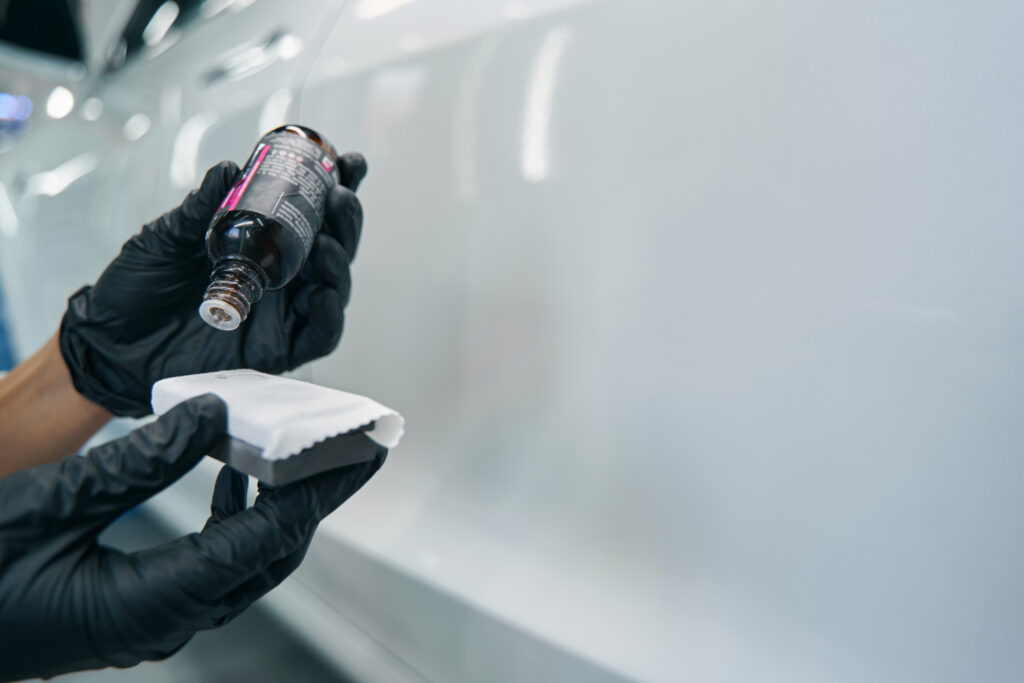 worker in nitrile gloves preparing tool for car polishing