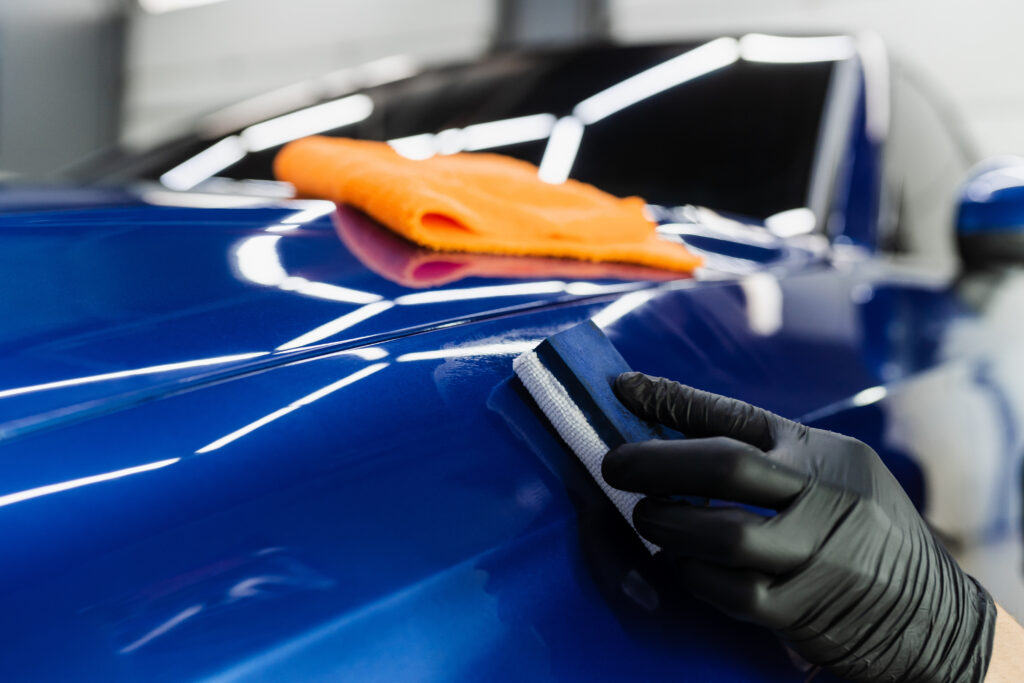 Keramik Behandlung Luzern mit präziser Applikation der Keramikversiegelung auf blauem Fahrzeuglack durch Auto Pro Deluxe.