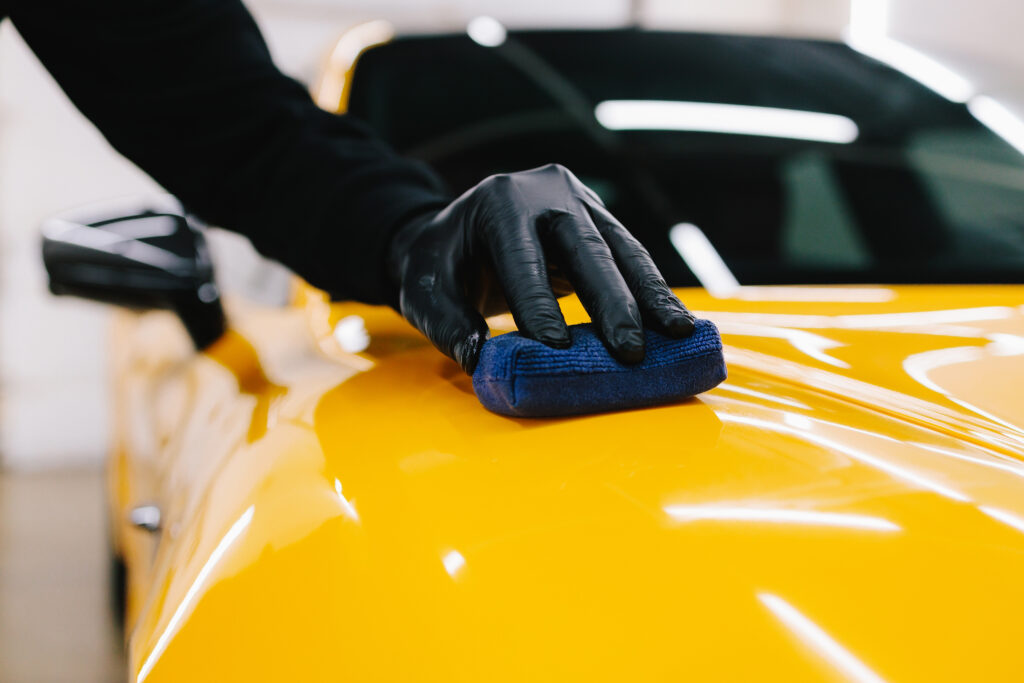 Keramik Behandlung Zug mit professioneller Applikation der Keramikbeschichtung auf gelbem Sportwagen für maximalen Glanz und Schutz.